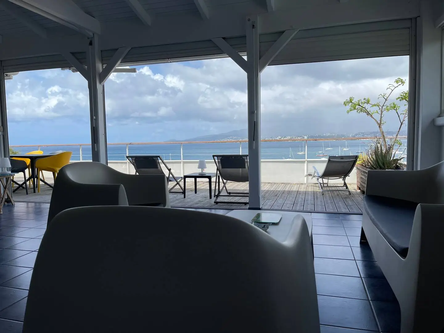 Espace salon confortable ouvert sur la terrasse panoramique avec vue mer et bateaux - Appartement Grand Large Trois Îlets Martinique