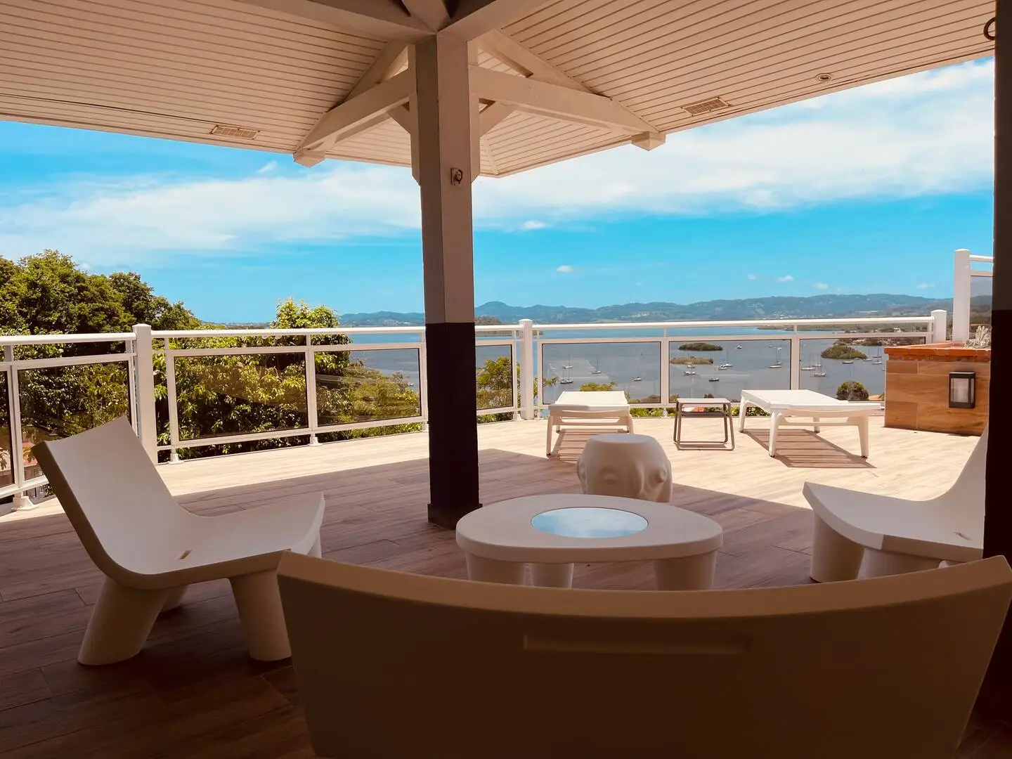 Espace lounge extérieur sur la grande terrasse avec chaises design et vue panoramique sur la mer des Caraïbes et les îlets - Villa Héliconia Trois Îlets Martinique