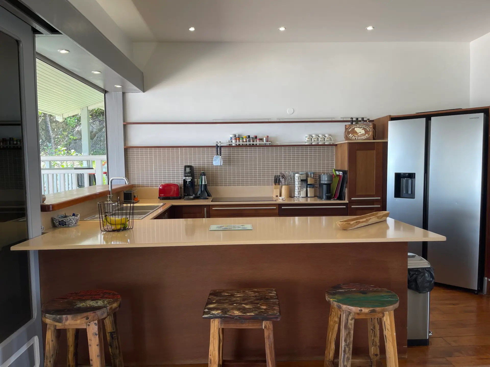 Cuisine entièrement équipée de la Villa Héliconia en Martinique, avec grand plan de travail, électroménagers modernes et réfrigérateur américain.