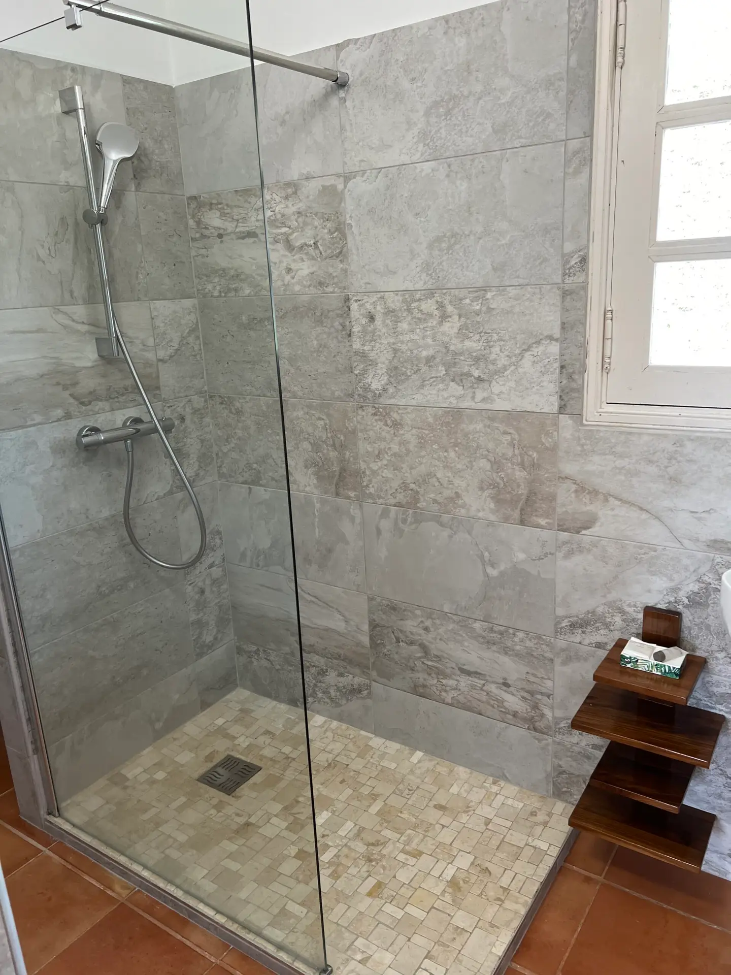 Salle d’eau de la Villa Thalizia en Martinique, équipée d’une douche à l’italienne moderne avec carrelage effet pierre.